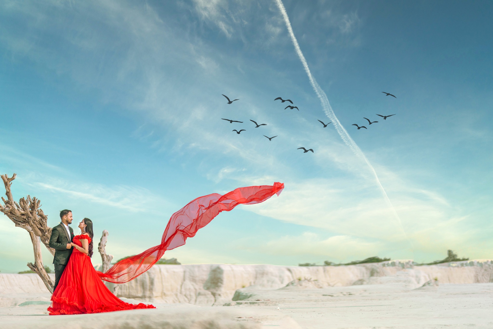 Pre-wedding couple portrait in a desert with a red gown