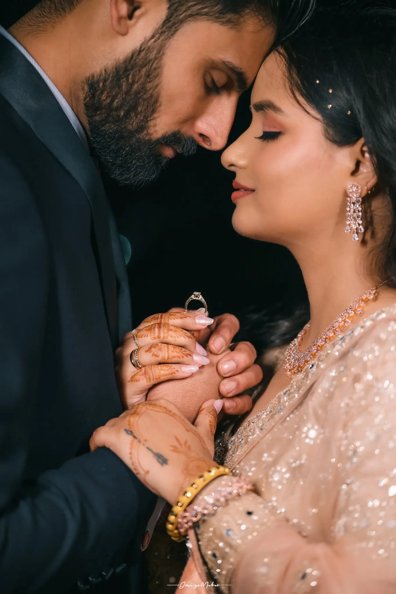 Engaged couple holding hands while the bride displays her ring