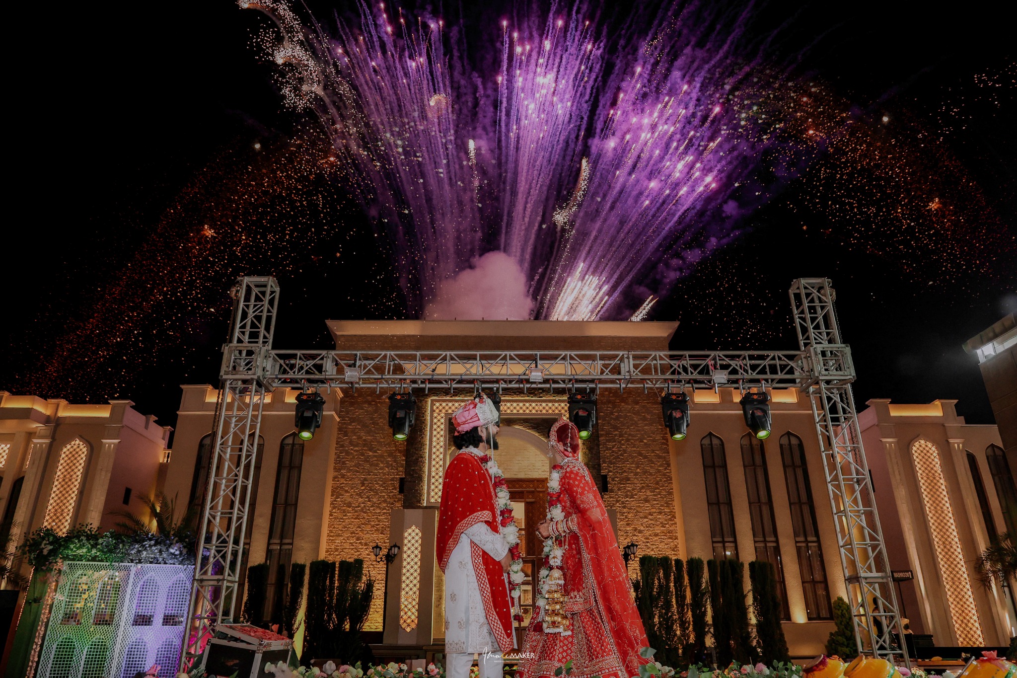 Newlywed couple celebrating outdoors under fireworks